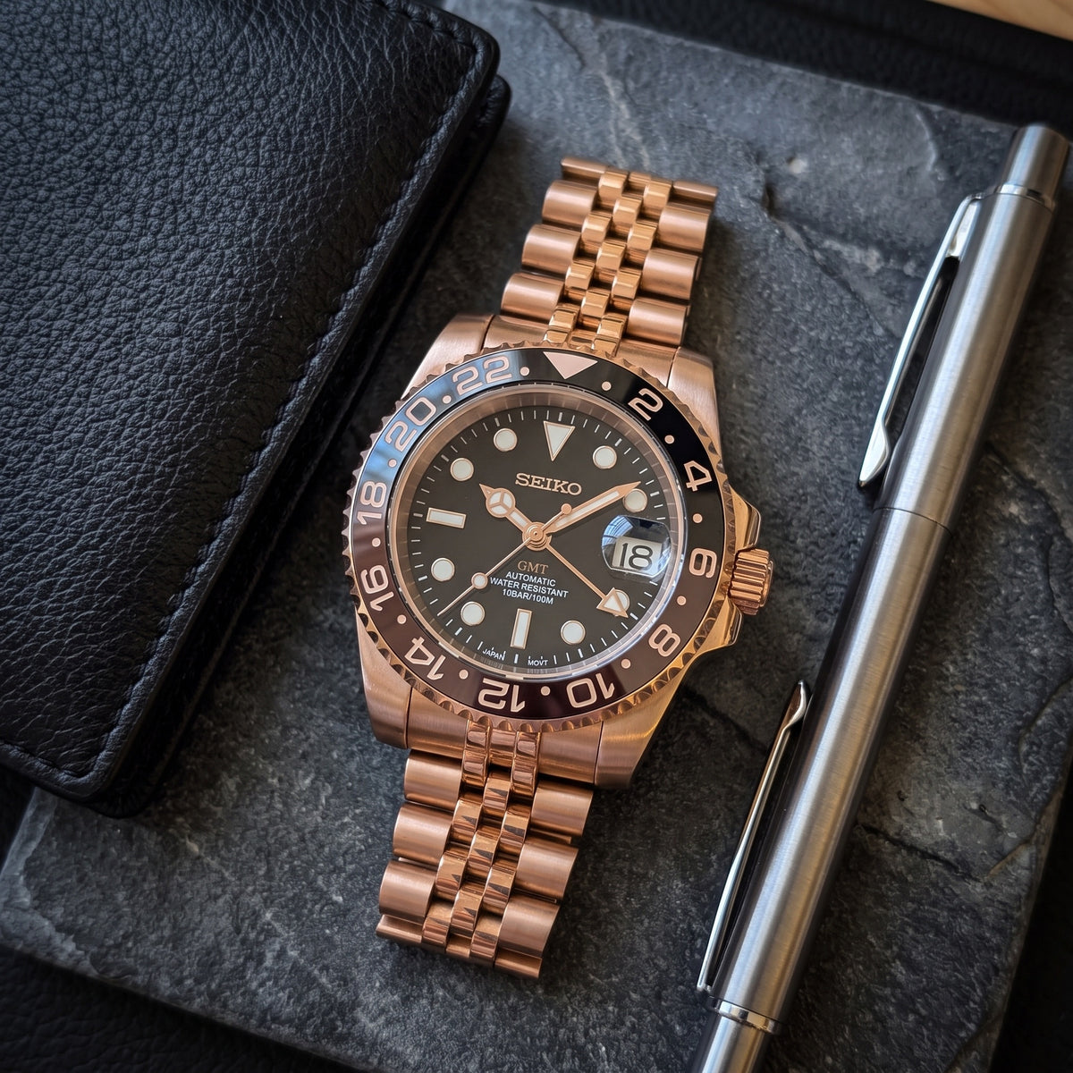 GMT Mod – Rose Gold · Brown-Black Bezel · Jubilee – 40mm – Automatic GMT – lifestyle flat lay
